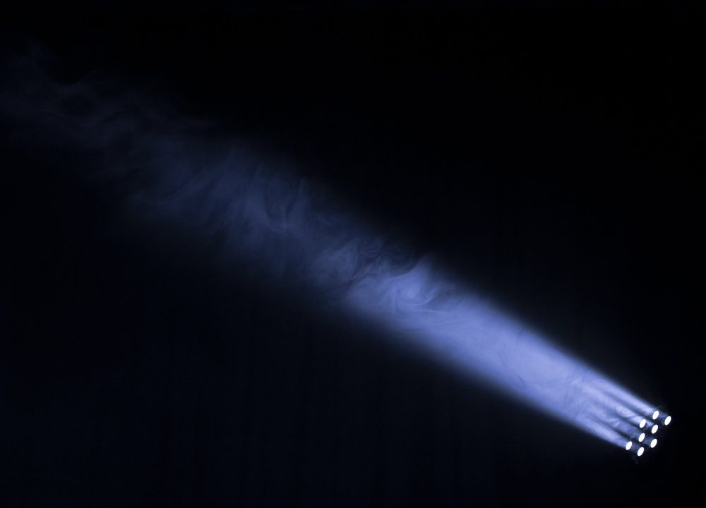 Beams of light cutting through haze in a dark space